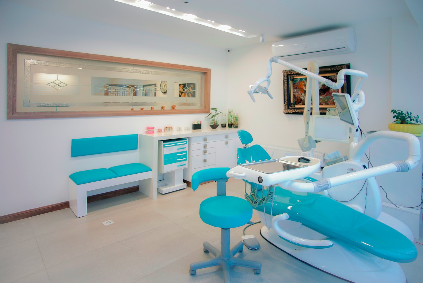 Turkuaz koltuk ve bekleme bankı olan modern dişçi kliniği.